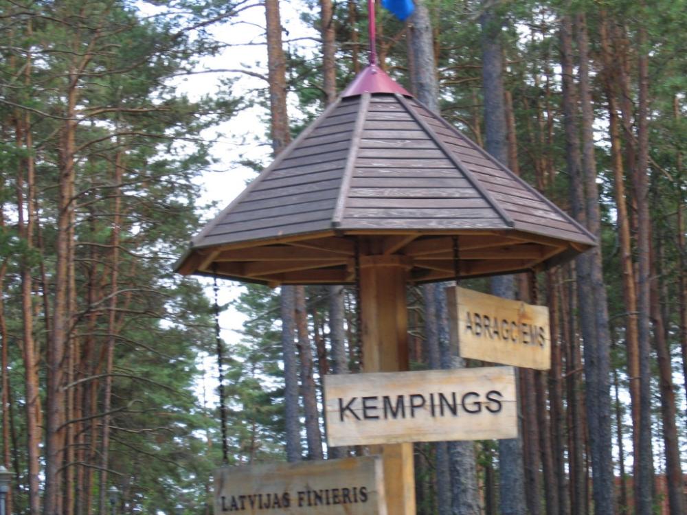 Koka norādes uz kempingu priežu mežā
