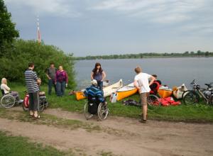 Dalībnieki ar laivām pulcējas Daugavas krastā
