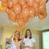 Dalībnieces ar oranžu balonu pušķi
