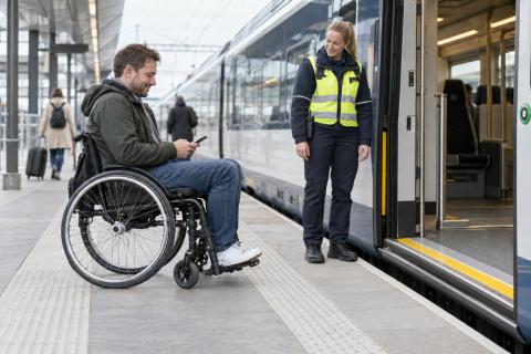 Stacijas darbiniece sagatavo rampu pasažierim riteņkrēslā pie vilciena durvīm