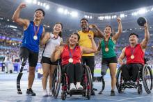 Dažādu parasporta disciplīnu sportisti stadionā kopā svin izcīnītās medaļas
