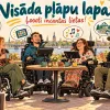 Četri cilvēki ratiņkrēslos sēž pie āra galdiņa, runājot un smejoties.